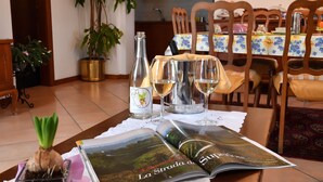 A dining table with a magazine, wine glasses, and a bottle. - Agriturismo Memento (Follina)