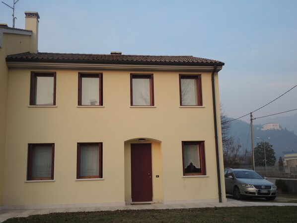 A two-story building with a red door and multiple windows. - Agriturismo Memento (Follina)