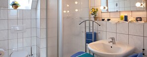 A bathroom with a white sink, a mirror, and a towel rack.