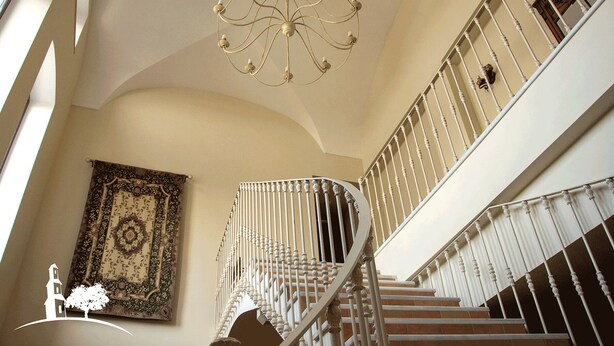 Un magnifique escalier avec des balustrades blanches et un lustre.