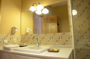 A bathroom with a white sink, a mirror, and a towel rack. - Hotel Rural Casas de Don Adame  (El Viso)