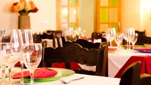 Une table à manger dressée avec de nombreux verres à vin et des assiettes, une serviette rouge et une fourchette sont visibles.