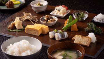 A variety of dishes including rice, soup, and sushi on a wooden table.