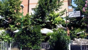 Un hotel de varios pisos con techo plano y un cartel que indica que pertenece a la cadena de hoteles Alberghetto Carezza.