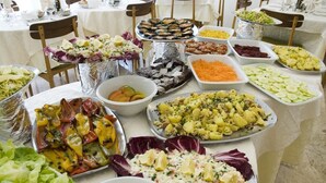 Una mesa de buffet con diversos platos, entre ellos ensaladas, carnes y verduras.