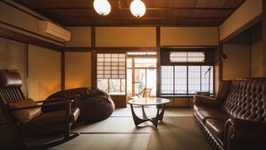A traditional Japanese room with tatami flooring, a low ceiling, and sliding doors. - UCHIKO-Inn (Uchiko)