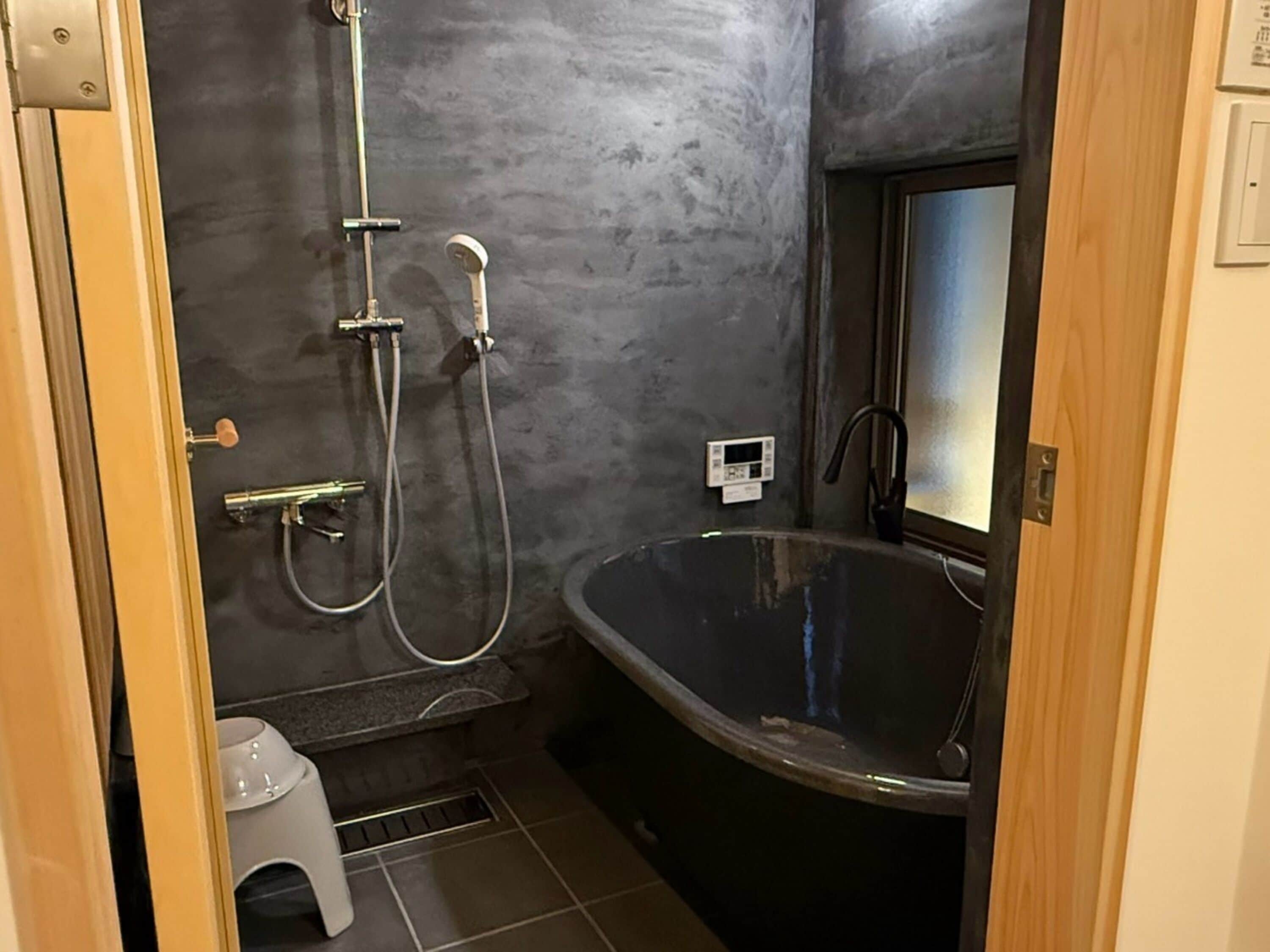 Un baño con bañera independiente, ducha con cabezal de ducha manual y grifo empotrado.
