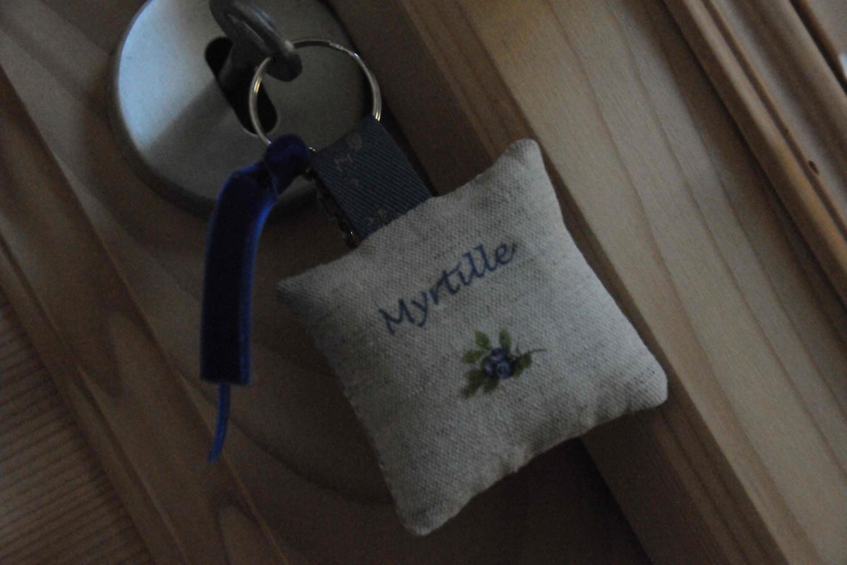A small embroidered keychain with the name "Myrtle" and a blue flower design.