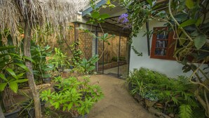 Un jardin agrémenté de plantes en pot, un mur de pierre et une porte en bois.
