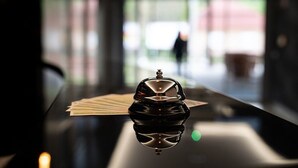 A reflective black table with a silver object and a piece of paper. - Hotel Kristály (Ajka)