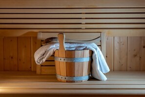 A wooden sauna bench with a wooden bucket and a towel. - Post Residence Apartments 11A, sauna, SUMMER CARD (Zell am See)