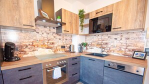 Eine moderne Küche mit Holzausziehtüren, einer Ziegelrückwand, einer Mikrowelle, einem Backofen und einem Geschirrspüler.