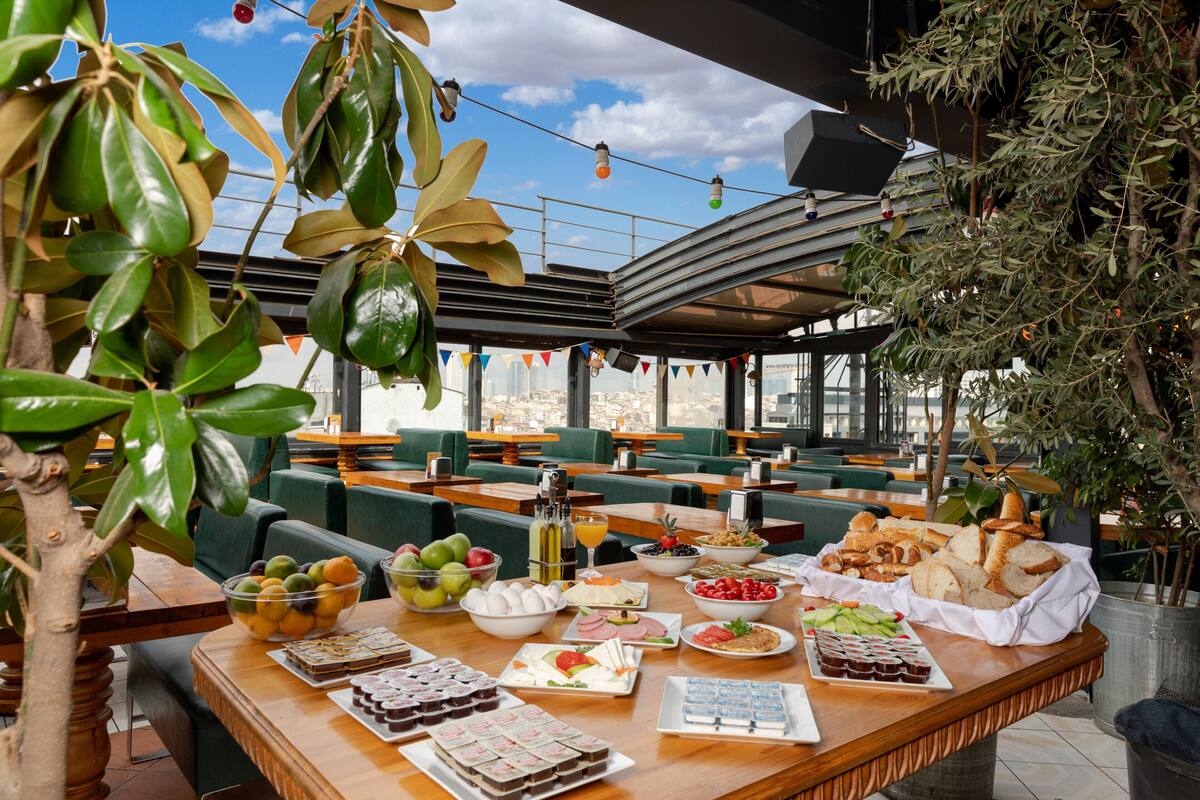 Ein Restaurant mit Außenbereich, vielfältigen Speisen und Getränken sowie Blick auf die Stadt.