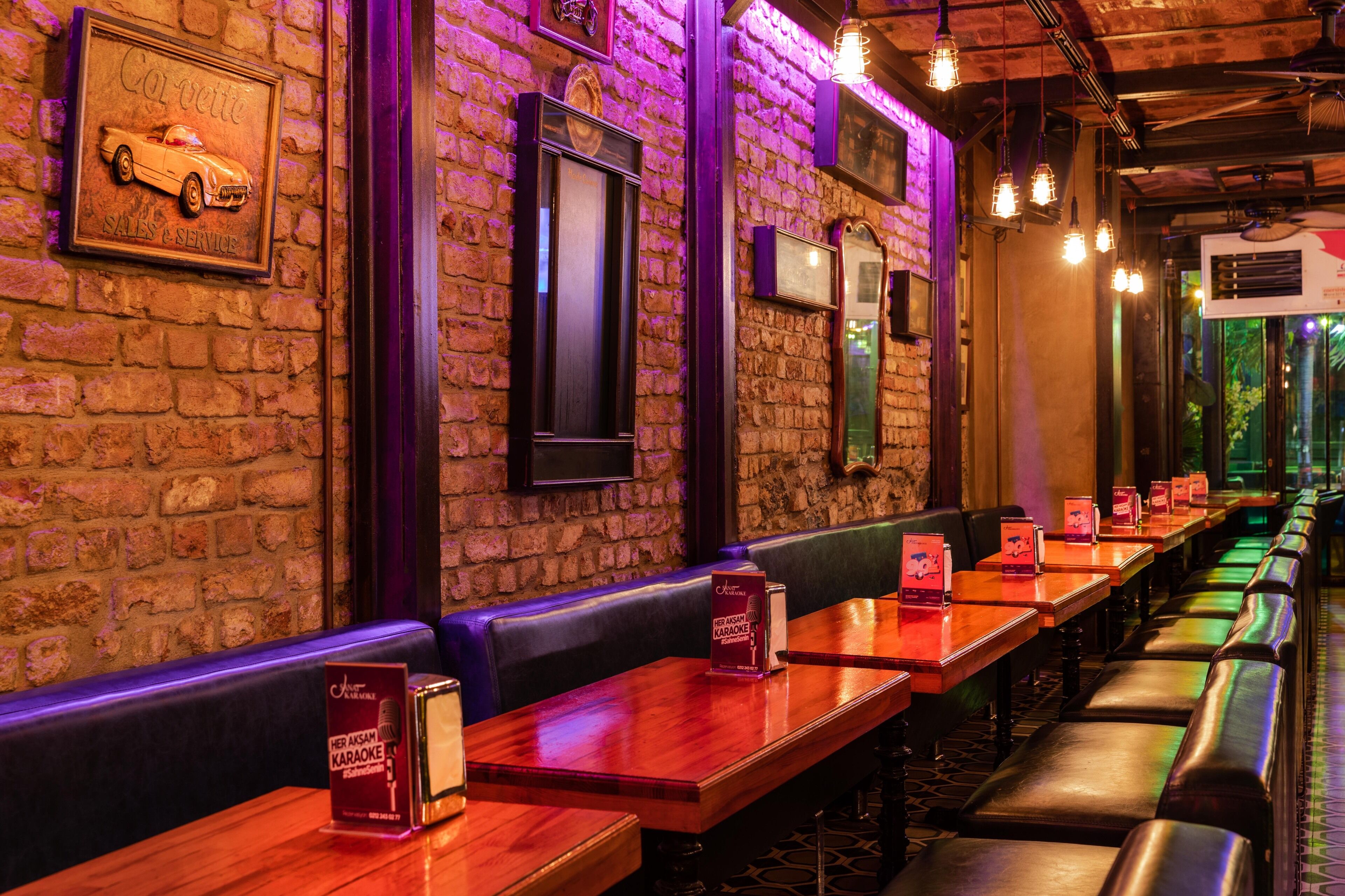 A restaurant with brick walls, wooden tables, and leather booths.