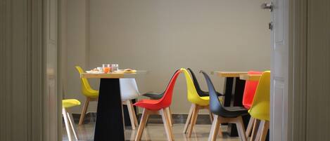 A dining area with a table and chairs, a door, and a tiled floor.