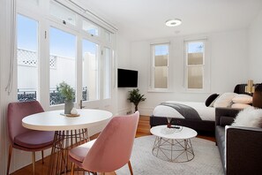 Relax in a spacious living room with a sofa, dining table, and flat-screen TV.