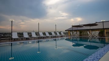 Una piscina al aire libre, sillones reclinables de piscina