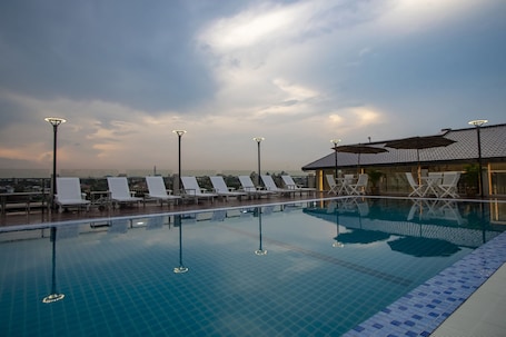 Una piscina al aire libre, sillones reclinables de piscina