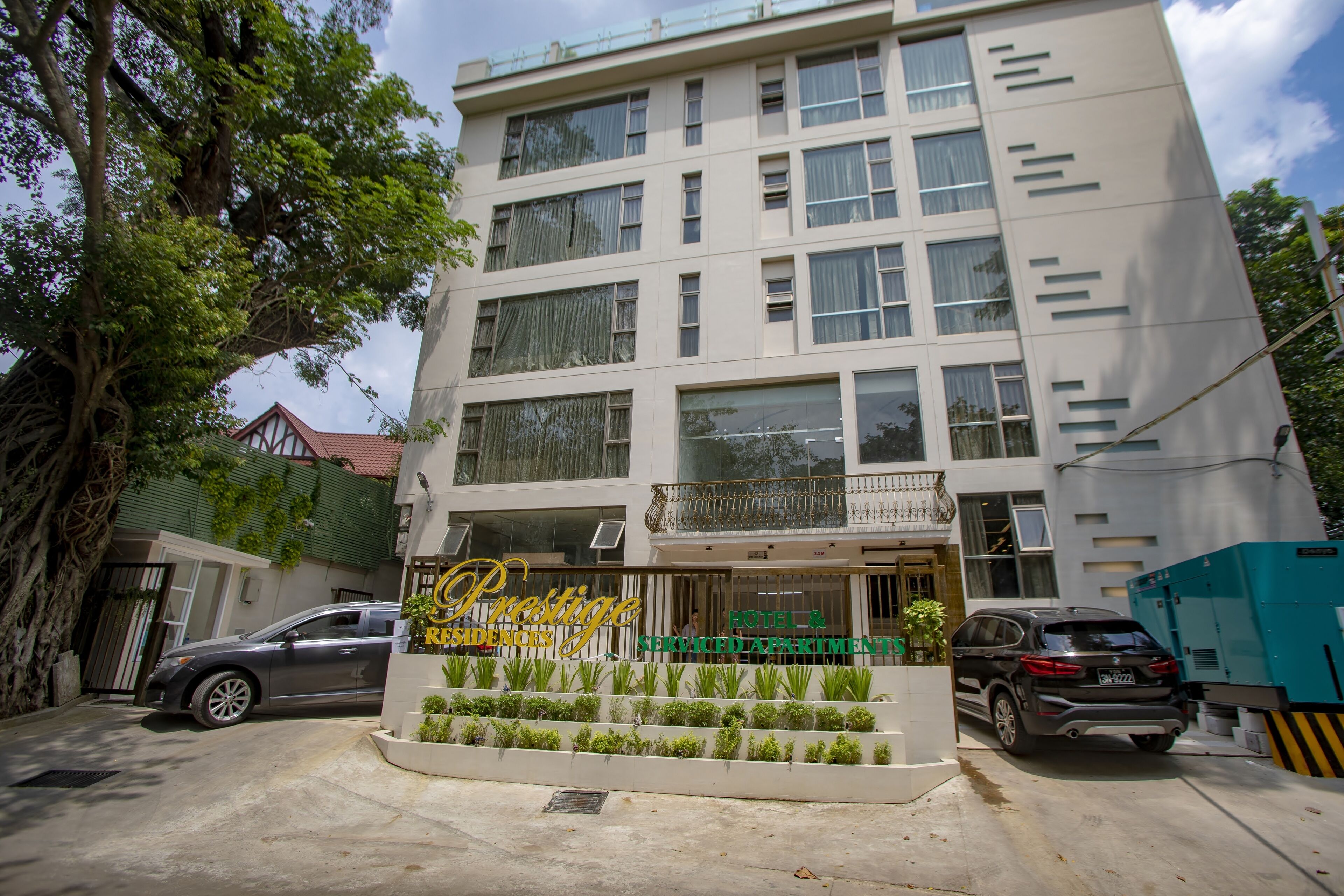 A multi-story hotel with a signboard reading "Prestige Residences Hotel & Suites".