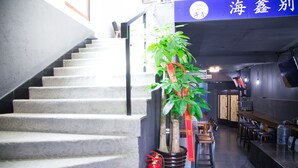 A staircase with a fire extinguisher and a potted plant. - Villa Haixin (Qingdao)