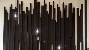 A reception desk with a wooden panel design, a white Apple iMac, and a blue informational sign. - Villa Haixin (Qingdao)