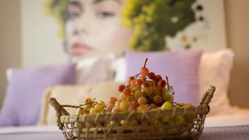 Una cesta de mimbre llena de uvas sobre una mesa con mantel a cuadros.