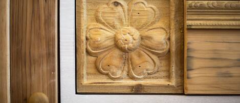 A close-up of a wooden door with a round knob and a carved floral design.