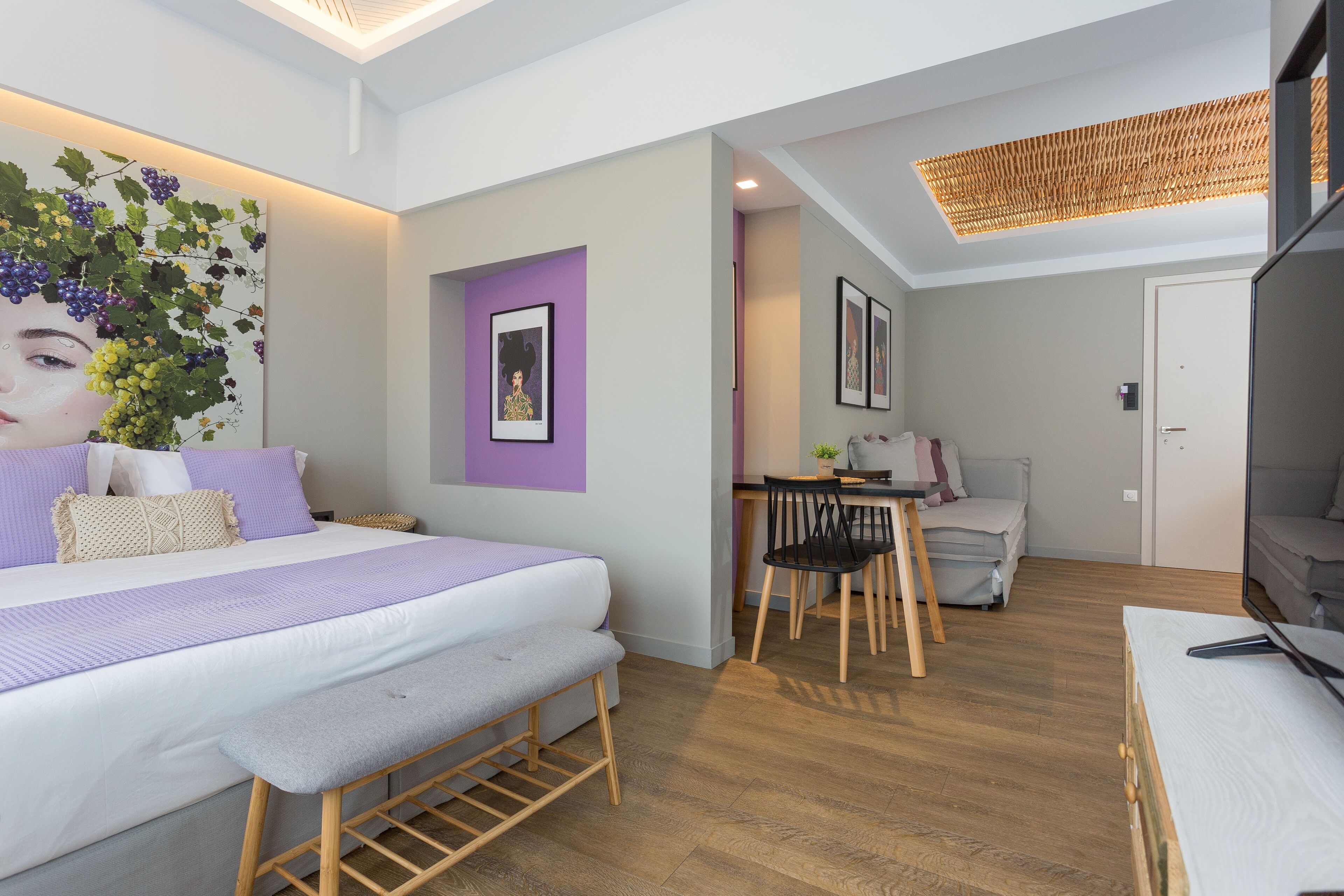 Un dormitorio moderno con una cama grande, un banco, un escritorio y una silla.