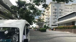 Un fourgon blanc est garé sur une surface pavée, avec un bâtiment en arrière-plan.