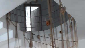 A staircase with a rope climbing wall in the background. - ADA KEKİĞİ PANSİYON (Gökçeada)