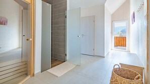 A modern interior with a glass door leading to a balcony, a wooden floor, and a wicker basket.