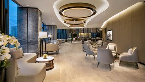 A modern hotel lobby with a curved ceiling, comfortable seating, and a large window offering a city view. - Ascott Songshan Lake Dongguan (Dongguan)
