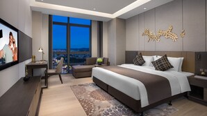 A modern hotel room with a large bed, a desk, a chair, and a TV. - Ascott Songshan Lake Dongguan (Dongguan)
