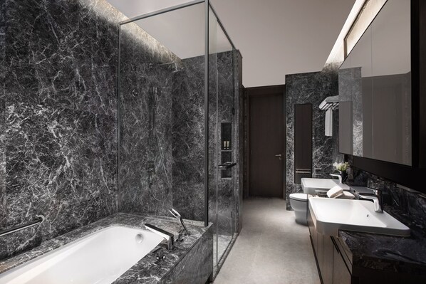 A modern bathroom with a glass-enclosed shower, a freestanding bathtub, and a vanity with a large mirror.