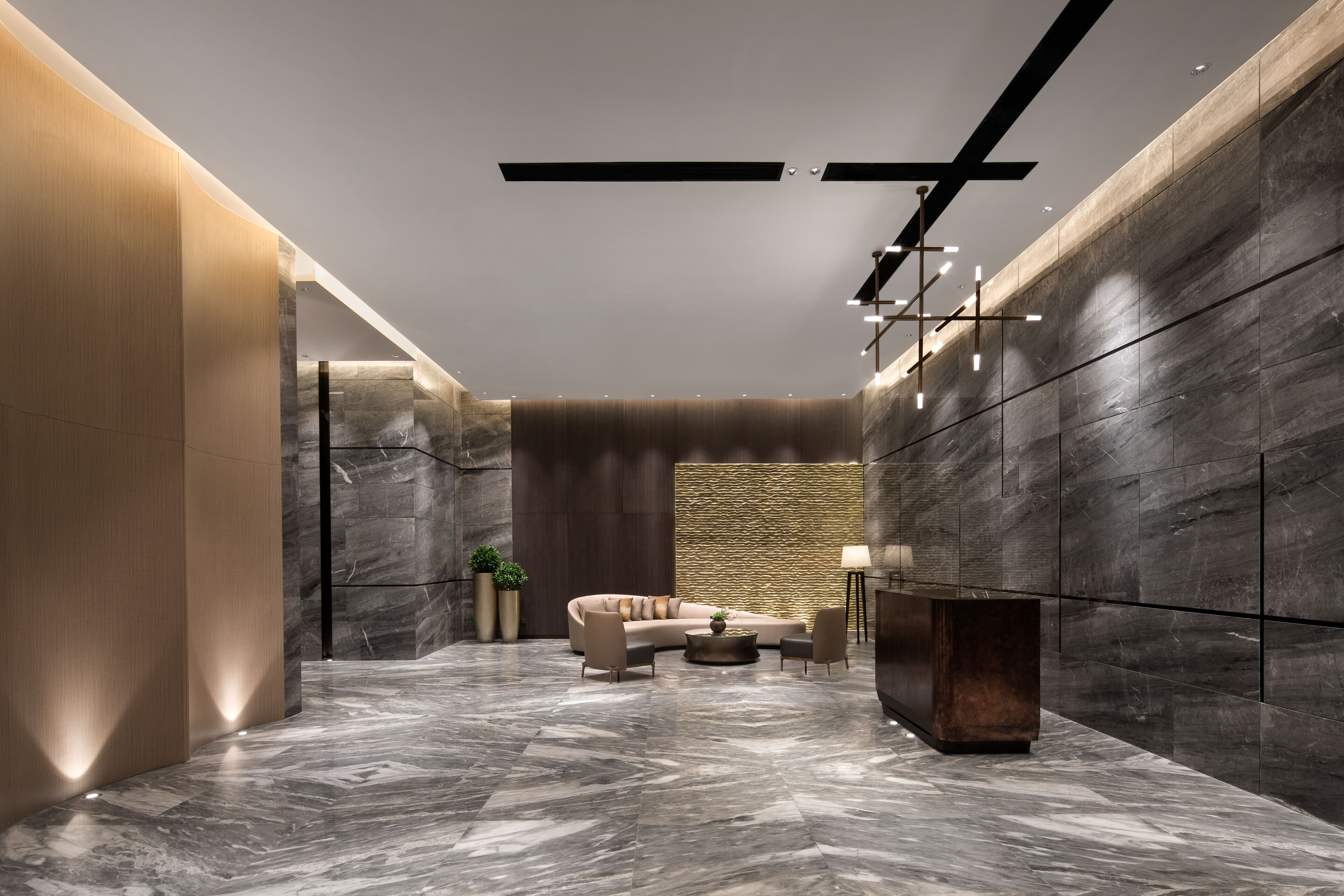 A modern lobby with a marble floor, a sofa, a coffee table, and a TV.