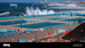 A coastal swimming pool with multiple lanes, a lifeguard tower, and a lighthouse in the background. - Marina Casablanca by Saloua (Casablanca)