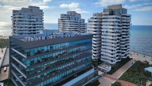 A modern high-rise building with multiple balconies, large windows, and a rooftop terrace. - Marina Casablanca by Saloua (Casablanca)