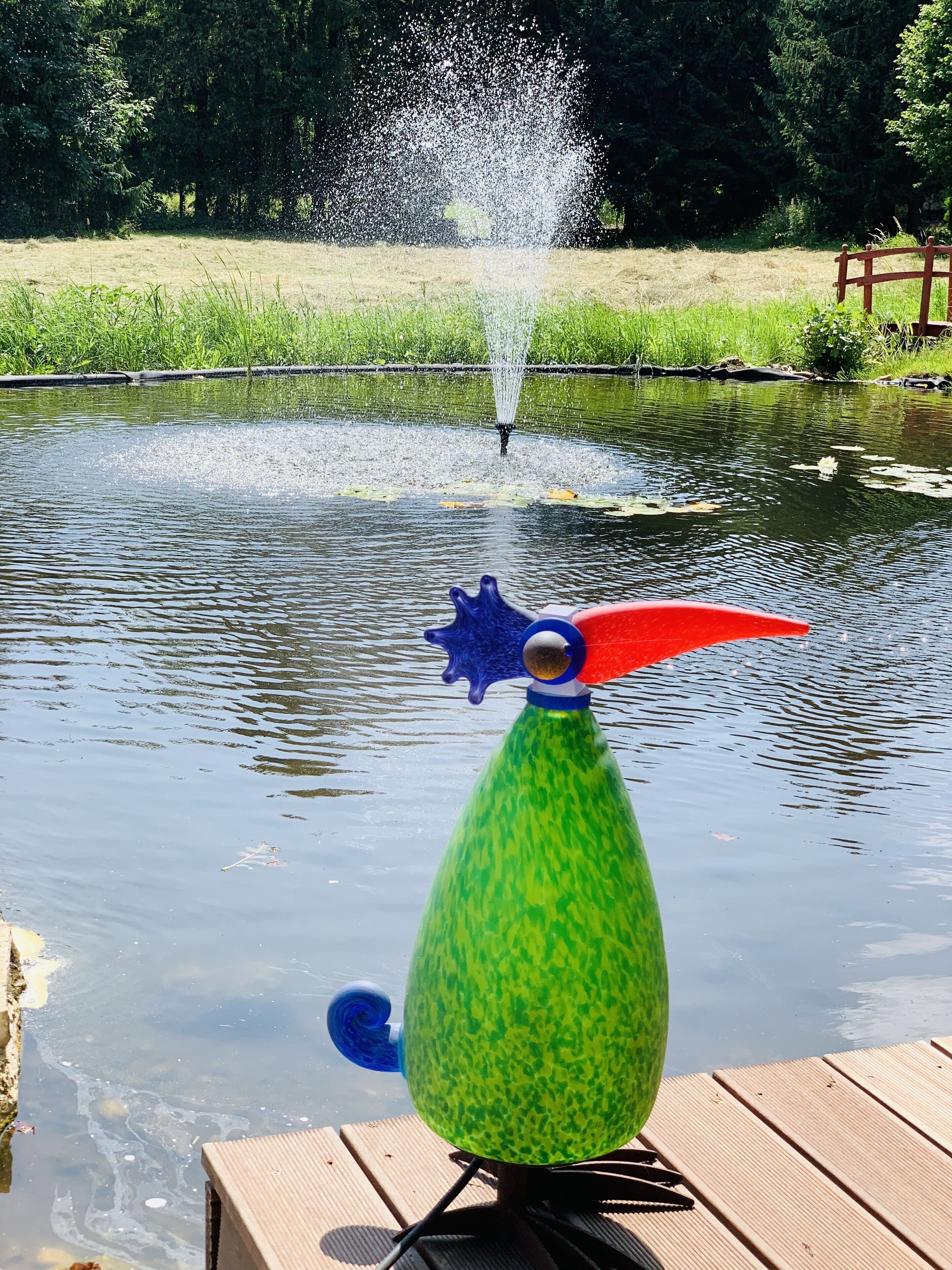 A water fountain with a colorful sculpture in the foreground.