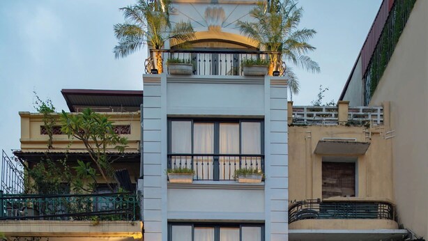 Un hotel con una facciata moderna, balconi con piante e una vetrina con il cartello che indica "Fiesta Central Hotel and Spa".