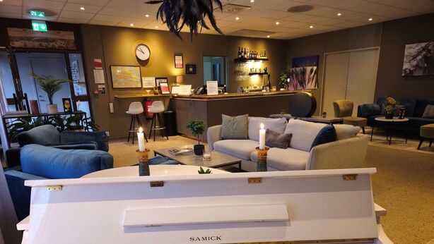 A piano in a hotel lobby with seating areas and a bar. -  Lidingö Arena Hotel (Lidingo)