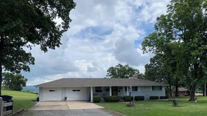 A single-story house with a garage, a front porch, and a well-maintained lawn. - Tenkiller Bluff House (Park Hill)