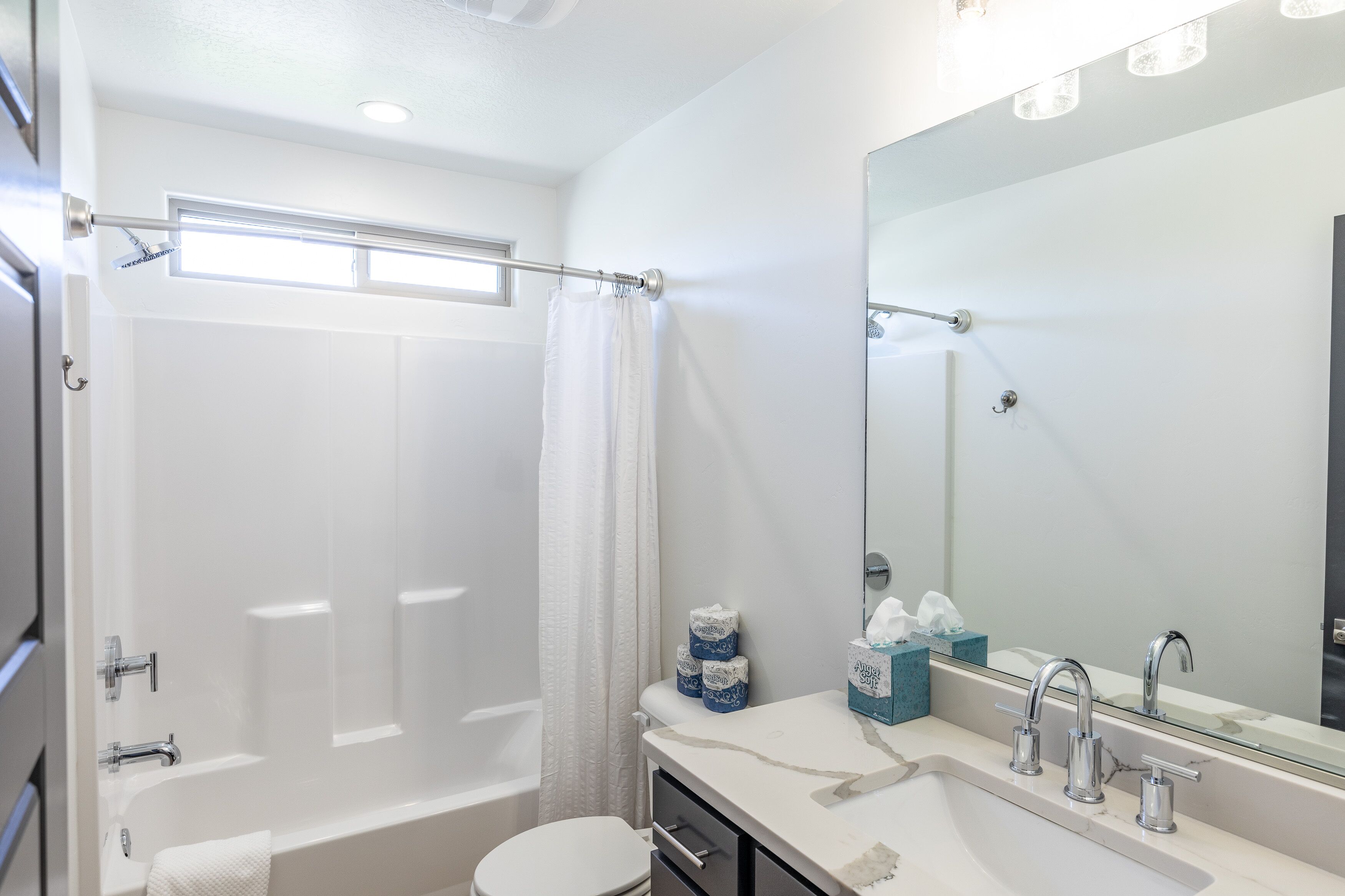 A modern bathroom with a bathtub, toilet, and sink.