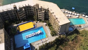 A hotel with a pool area, multiple balconies, and a view of the sea. - St Paul Resort and Apartments (Safra)