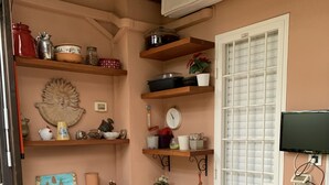 Una cocina acogedora con estantes de madera, una mesa de comedor y un televisor.