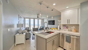 A modern kitchen with a central island, stainless steel appliances, and a dining area with a view.