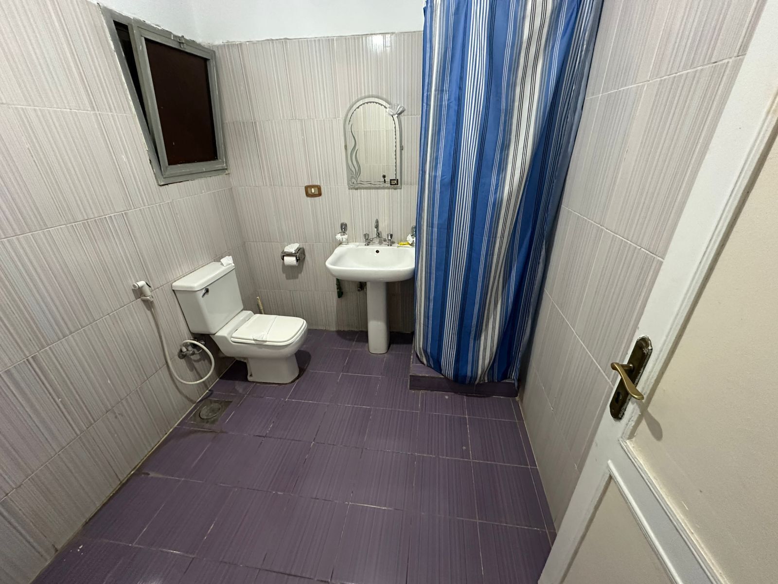 Une petite salle de bain avec des toilettes, un lavabo et un rideau de douche.
