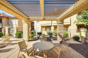Une terrasse extérieure dotée d’une pergola, de sièges et de barbecues.