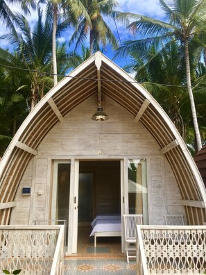 A bungalow with a triangular roof, a bed, and a balcony. - The Vagary Vibes (Penida Island)