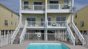 A two-story building with balconies, a swimming pool, and a lifebuoy. - Fantastic Oceanfront Home/Lgprivpool/Wifi/A+Location-Call/text 4046643546 (Gulf Shores)