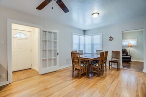 Cozy room with a dining area, featuring a table and chairs, and a comfortable seating area with a lamp.